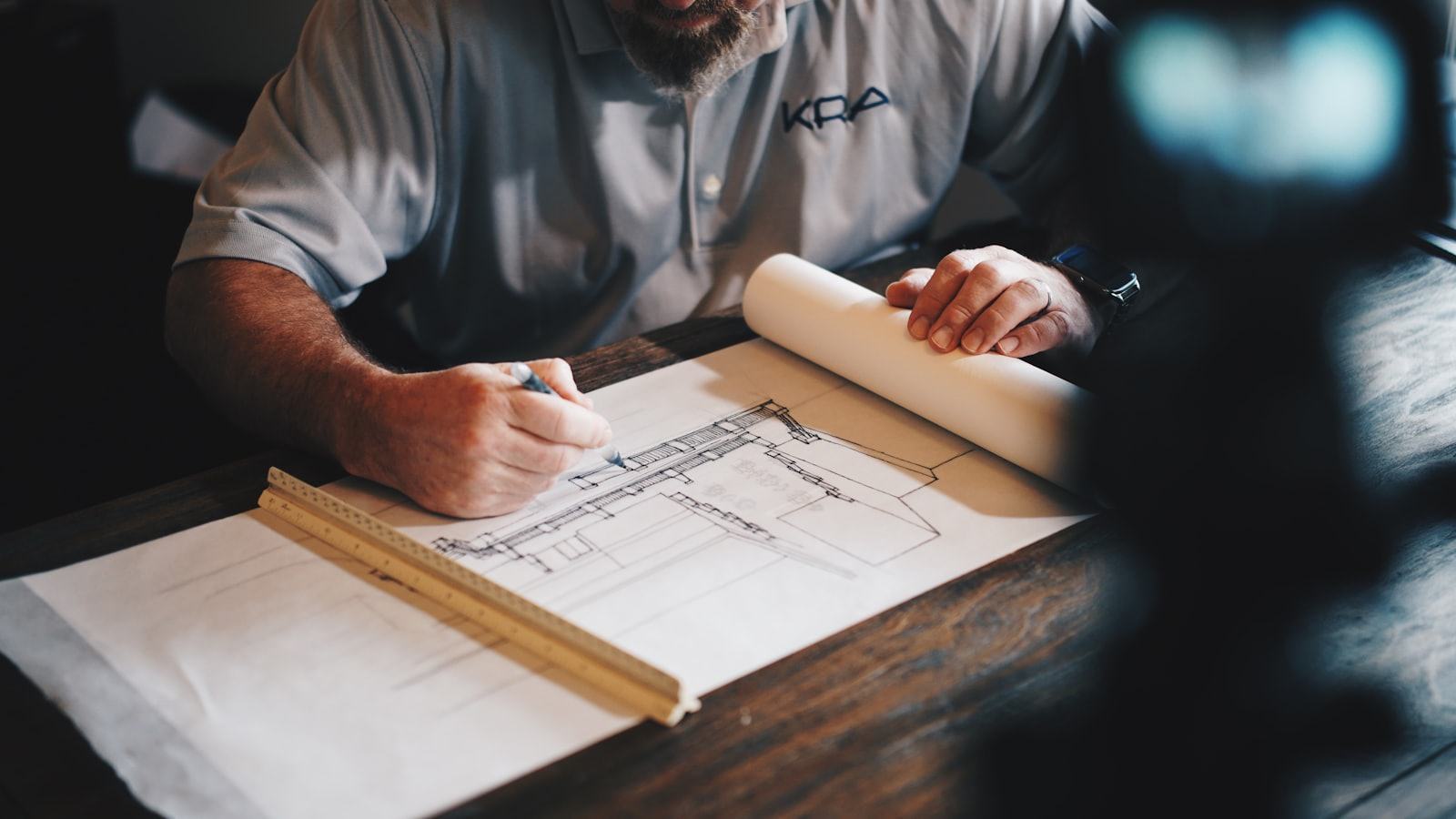 Architectural blueprints and drawing tools laid out on a desk