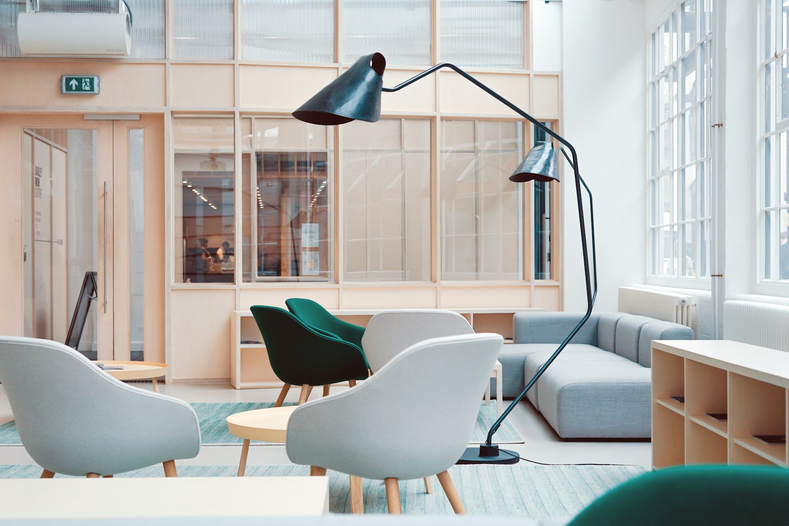 Furnished office lounge with upholstered chairs, sofa, side tables and storage cabinets